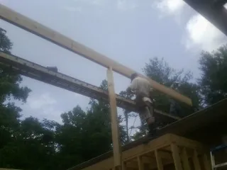 Carpenter setting a ridge beam over a new addition frame — Ice Dam Removal by Roofing Brothers in Denhoff